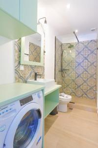 y baño con aseo y lavadora. en Kaminaki Beachfront Apartments, en Nisakion