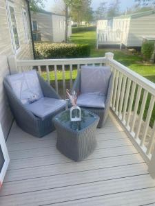 two chairs and a table on a deck at Community Wishes Retreat - Butlins Passes Included in Lincolnshire