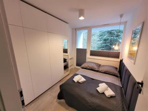 una piccola camera con letto e finestra di Apartament z sauną Polanica-Zdrój a Polanica-Zdrój