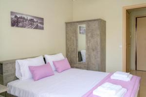 ein Schlafzimmer mit einem großen weißen Bett mit rosa Kissen in der Unterkunft Sunshine Apartments #01 in Thessaloniki