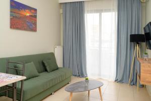 ein Wohnzimmer mit einem grünen Sofa und einem Tisch in der Unterkunft Sunshine Apartments #01 in Thessaloniki