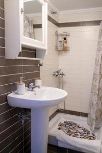 ein Bad mit einem Waschbecken und einem Spiegel in der Unterkunft Sunshine Apartments #01 in Thessaloniki