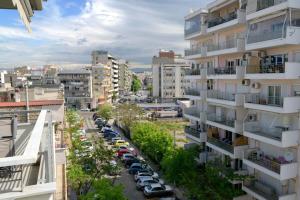 ein Apartmenthaus mit Autos auf einem Parkplatz in der Unterkunft Sunshine Apartments #01 in Thessaloniki