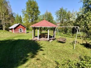 a gazebo with a picnic table and a swing at Mummola in Taluskylä