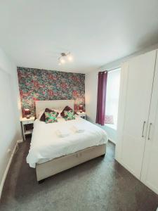 een slaapkamer met een groot wit bed en een raam bij Dubarry Downs Apartment with Hot Tub at Clevelands in Wroxall