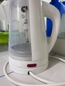 a white electric kettle sitting on top of a counter at Staycation condo with pool near SM Tungko, Bulacan in Mangangpico