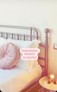 埃爾科萊港的住宿－Loraia Design Rooms，一张带粉红色枕头的床和上面的标志
