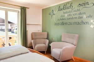 una camera con due sedie e un letto di Ferienwohnung BERGerholen a Mittenwald