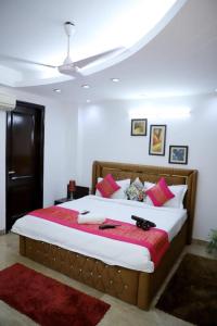 a bedroom with a large bed with red and white pillows at DIVINE INDIA SERVICE APARTMENT 3BHK, J-215 SAKET in New Delhi