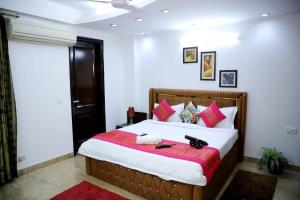 新德里的住宿－DIVINE INDIA SERVICE APARTMENT 3BHK, J-215 SAKET，一间卧室配有一张带红色枕头的大床