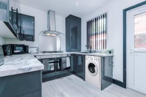 a kitchen with a washing machine and a washer at Mansa Musa House - 5 Bed 5 En Suite Bathrooms, Newly Refurbished House with free parking outside in Liverpool