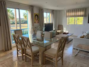 Una sala de estar con una mesa de cristal y sillas. en Sotogrande Marina Beach, en Sotogrande