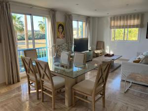 a living room with a glass table and chairs at Sotogrande Marina Beach in Sotogrande