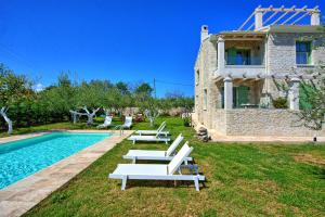 a villa with a swimming pool and a house at Villa Elaia by PosarelliVillas in Almiros Beach