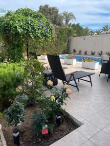 eine Terrasse mit einem Tisch, Stühlen und Blumen in der Unterkunft PARADISE GARDEN in Los Alcázares