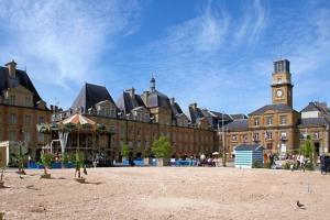 a large brick building with a clock tower on it at Maison de charme in Nouzonville