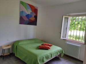 Un dormitorio con una cama verde y una ventana en Appartamento Il Picchio Verde en Altopascio