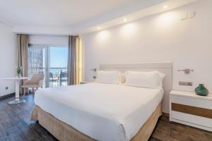 a bedroom with a large white bed and a balcony at INNSiDE by Meliá Alicante Porta Maris in Alicante