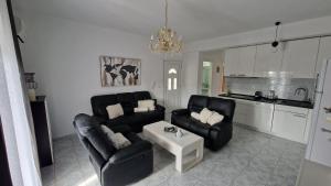 a living room with two black chairs and a table at Doukas Aparthotel in Ofrínion