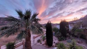 eine Palme vor einem Gebäude mit Sonnenuntergang in der Unterkunft Villa Mondriana in Mondrón