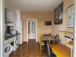 a kitchen with a table and a dining room at Albergue Pensión Flavia in Padrón