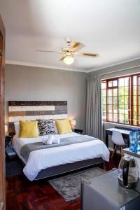 een slaapkamer met een bed en een plafondventilator bij Boutique Hotel on the Bay in Humewood