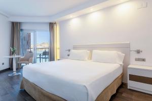 a hotel room with a large bed and a balcony at INNSiDE by Meliá Alicante Porta Maris in Alicante
