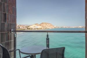 a table and chairs on a balcony with a view of the water at INNSiDE by Meliá Alicante Porta Maris in Alicante