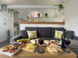 una mesa con platos de comida y copas de vino en The Little Barn en Hoxne