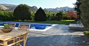 une terrasse avec une table, des chaises et une piscine dans l'établissement Impresionante villa entre mar y montaña, à La Cavada
