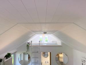 a bedroom with a bed in a white ceiling at The Little Barn in Hoxne