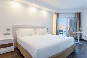 a hotel room with a large bed and a balcony at INNSiDE by Meliá Alicante Porta Maris in Alicante