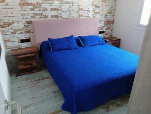 1 dormitorio con cama azul y almohadas azules en Apartamento en primera línea de mar, las Teresitas, Santa Cruz de Tenerife, en San Andrés