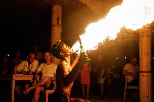 een man zonder shirt die een drankje uit een fles drinkt bij Kardia Resort Gili Trawangan A Pramana Experience in Gili Trawangan