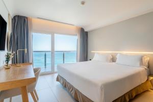 a bedroom with a large bed and a large window at INNSiDE by Meliá Alicante Porta Maris in Alicante
