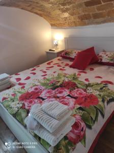 a bed with red roses and towels on it at Casa Dori in Rome