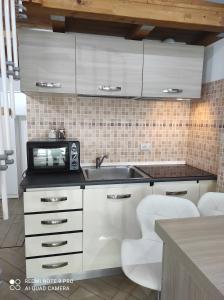 a kitchen with a sink and white cabinets at Casa Dori in Rome