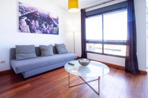 uma sala de estar com um sofá e uma mesa em Castilla Luz Deco em Madrid