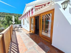 a house with a balcony with a wooden door at Cortijo Berruguilla in Lojilla