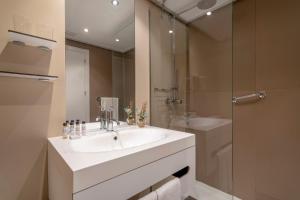 a white bathroom with a sink and a shower at INNSiDE by Meliá Alicante Porta Maris in Alicante