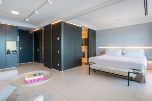 a bedroom with a white bed and a table at INNSiDE by Meliá Alicante Porta Maris in Alicante