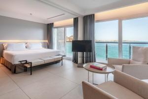 a hotel room with a bed and a view of the ocean at INNSiDE by Meliá Alicante Porta Maris in Alicante