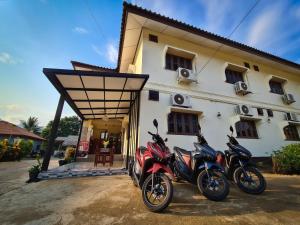 two motorcycles parked in front of a house at Saphaothong guesthouse in Vang Vieng