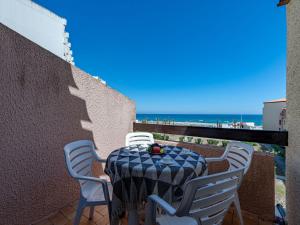 a table and chairs on a balcony with a view of the beach at Apartment Front de Mer-8 by Interhome in Le Barcarès