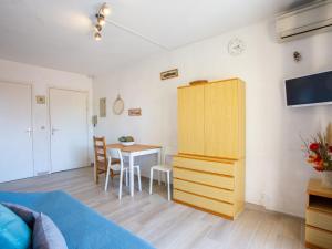 a bedroom with a bed and a table and a cabinet at Apartment Saint James-9 by Interhome in Le Lavandou