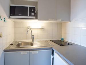 een keuken met een wastafel en een magnetron bij Apartment Saint James-9 by Interhome in Le Lavandou