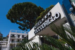 a sign for a hotel in front of a building at Coccodrillo Hotel & Apartments in Varazze
