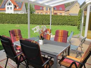 a wooden table and chairs on a patio at Holiday Home Alexorella by Interhome in Godern