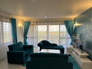 a living room with a couch and a chair and a television at Nyachaba Apartment in Kisumu