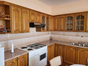 a kitchen with wooden cabinets and a stove top oven at Apartman Martina in Gospić